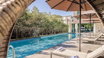 Una piscina al aire libre, sillones reclinables de piscina