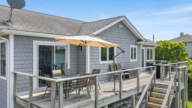 A house with a deck, outdoor furniture, and a satellite dish.