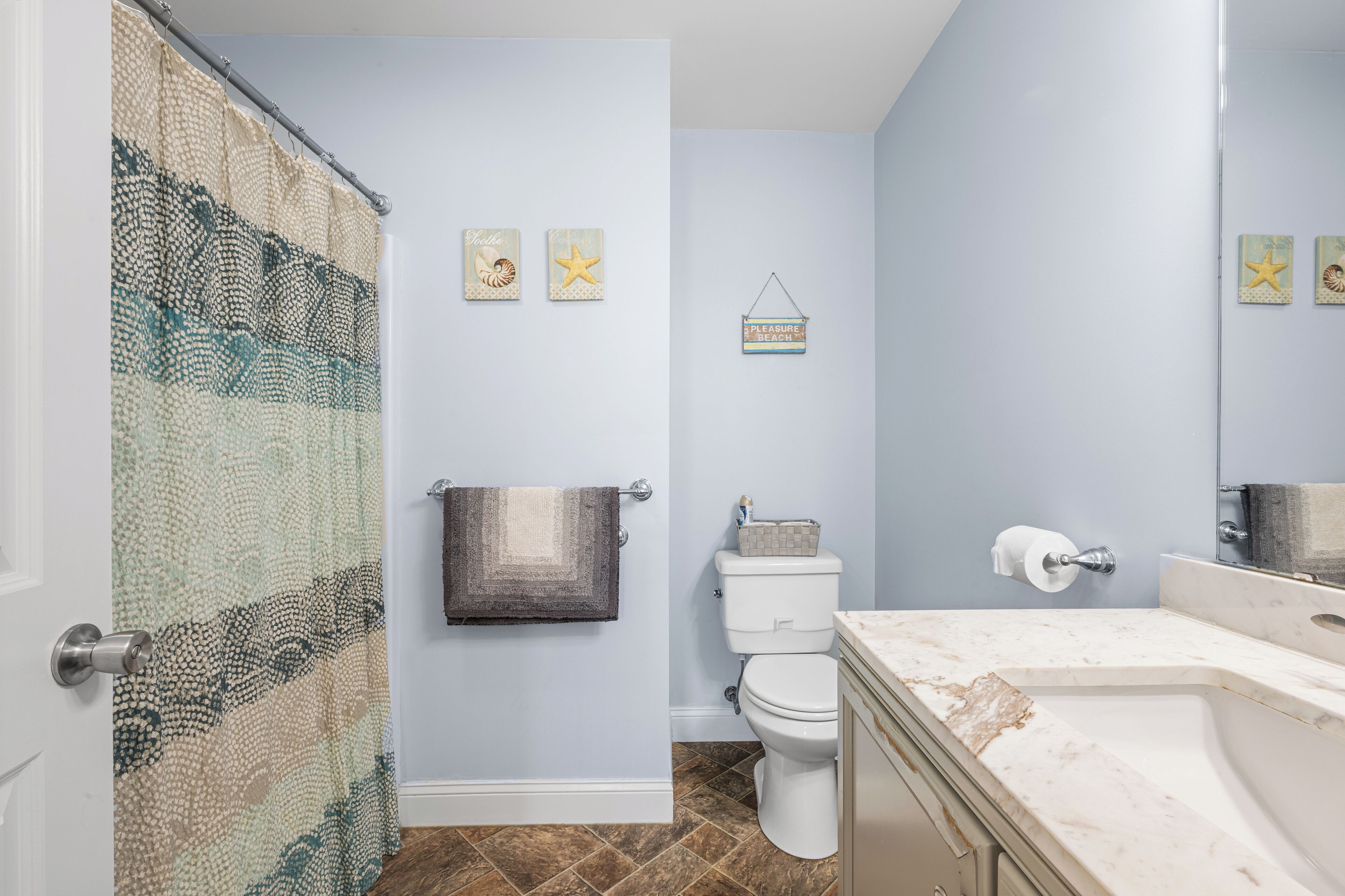A bathroom with a toilet, sink, and shower curtain.