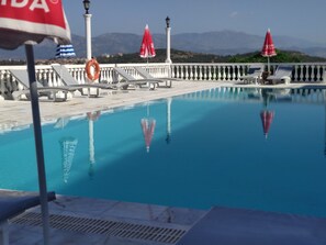 Piscina externa, guarda-sóis, espreguiçadeiras