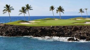 A coastal golf course with a rocky shoreline and palm trees. - Mauna Lani: Enjoy golf; snorkeling, helicopter tours Flexible cancellation terms (Kamuela)