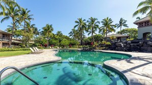 A swimming pool with a curved design, surrounded by palm trees and a stone deck. - Mauna Lani: Enjoy golf; snorkeling, helicopter tours Flexible cancellation terms (Kamuela)