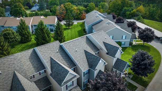 A residential area with multiple two-story houses, each with a sloped roof and a small front yard.
