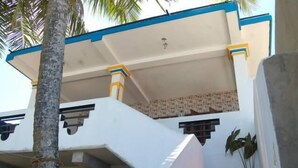 A multi-level building with white walls, blue trim, and a balcony with yellow accents. - Githmini Beach Guest House & Toures (Hikkaduwa)