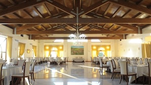 A spacious dining hall with high wooden ceilings and chandeliers, featuring multiple tables and chairs arranged for dining. - Tenuta Antico Leccio (Gioia del Colle)