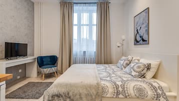 A modern bedroom with a bed, a desk, a chair, and a window with curtains.