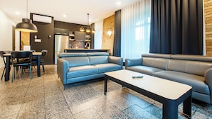 A modern living room with a sofa, coffee table, and dining area. - Les Lofts de la Gare - By Les Lofts Vieux-Quebec (Québec City)