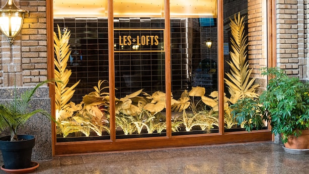 A storefront with a sign reading "LES LOFTS" and large potted plants in front. - Les Lofts de la Gare - By Les Lofts Vieux-Quebec (Québec City)