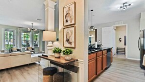 A modern kitchen with wooden cabinets, a built-in oven, and a stainless steel refrigerator.