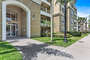 A multi-story residential building with a gated entrance, balconies, and a well-maintained lawn.