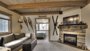 Ein gemütliches Wohnzimmer mit Kamin, einer Couch und einem Fernseher.