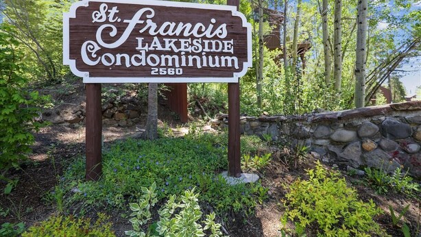 Un panneau en bois indiquant « St. Francis Lakeside Condominium », avec le numéro 2560.
