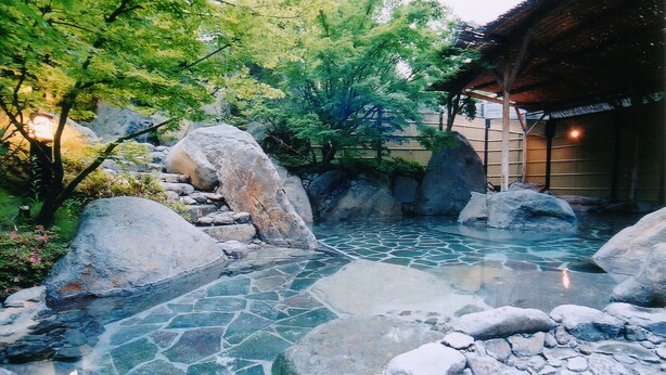 A traditional Japanese garden with a stone pathway, large rocks, and a clear water feature. - Kogane Sansou (Nakatsu)