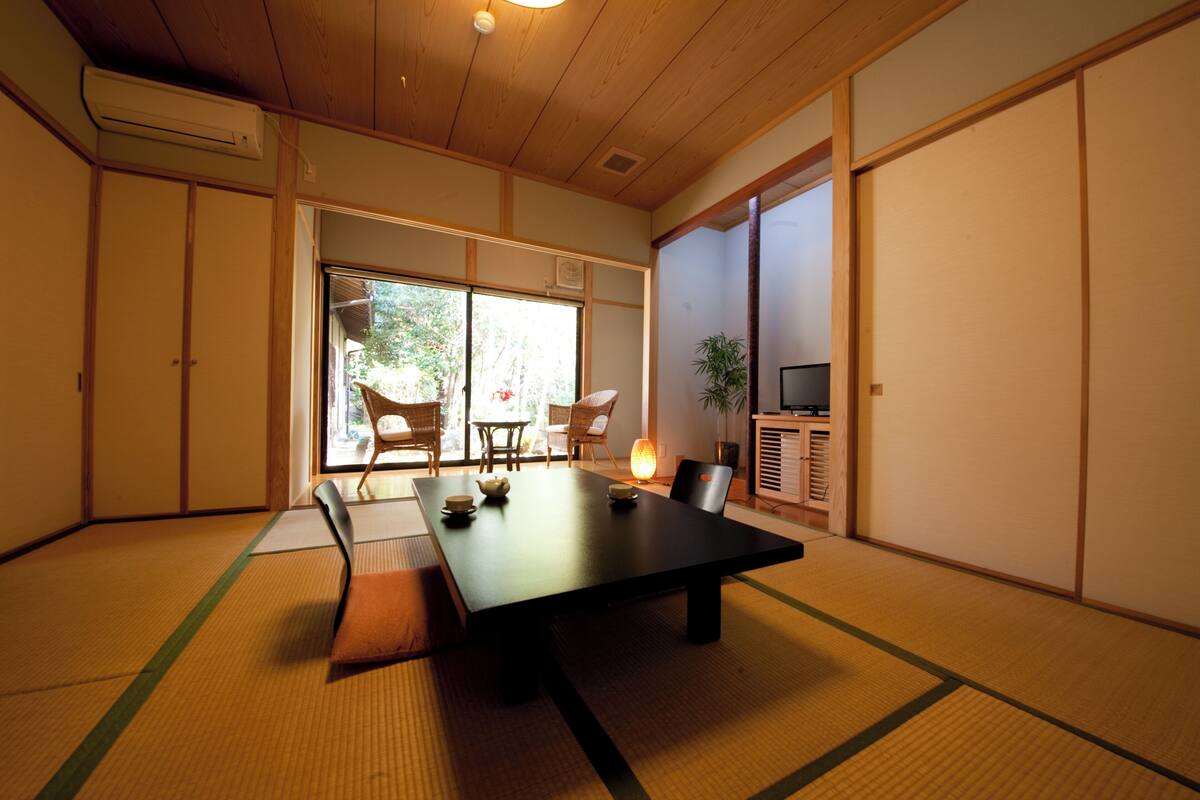 Una habitació japonesa tradicional amb sòls de tatami, una taula baixa i portes corredisses.