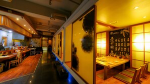 A restaurant with a long counter, wooden flooring, and traditional decor. - Bolton Hotel (Gwangju)