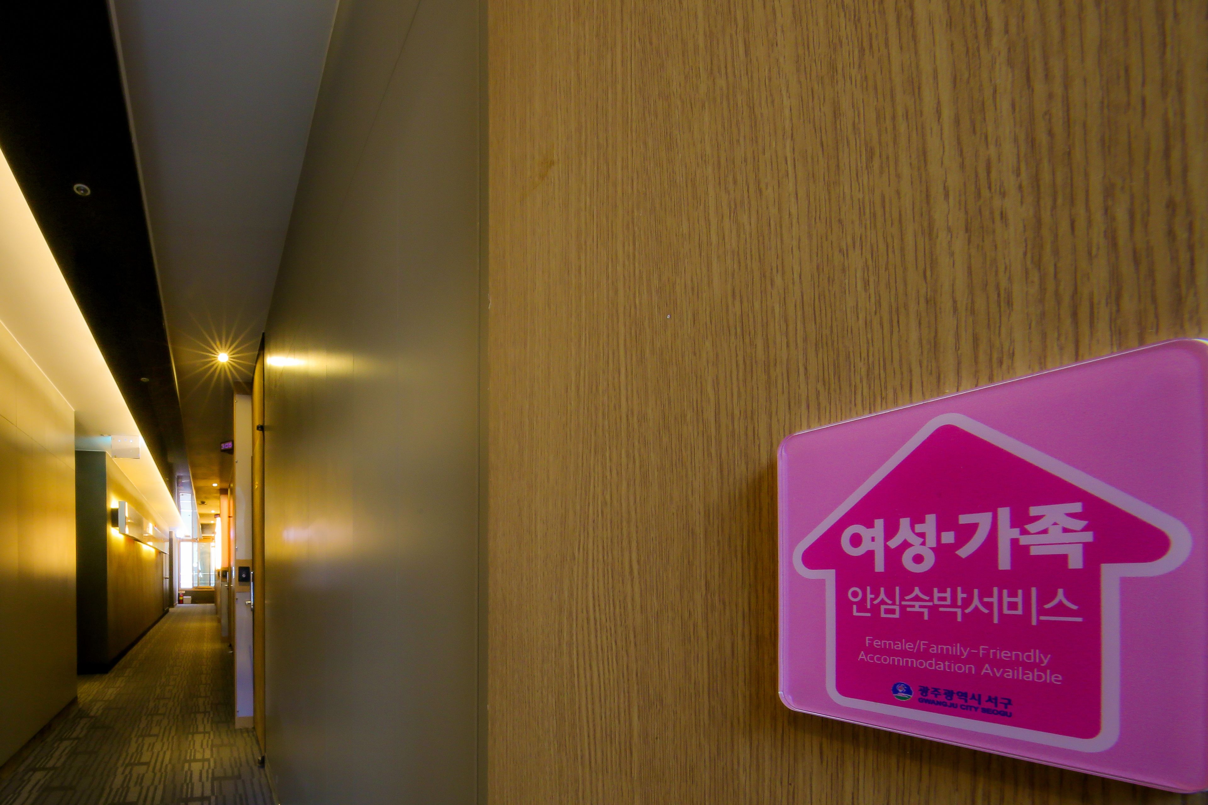 A hotel corridor with a sign indicating female/family-friendly accommodation.