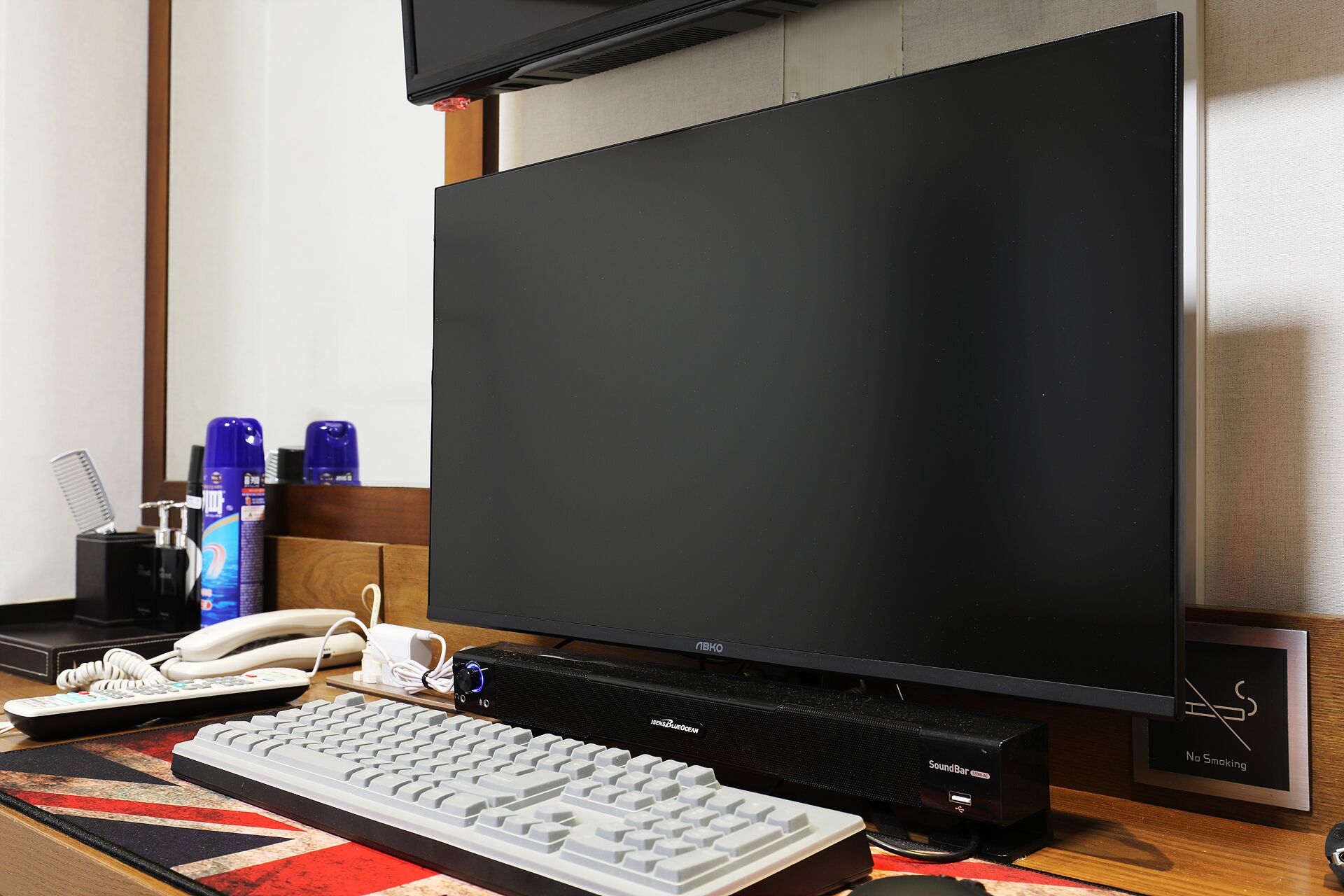 A computer setup with a monitor, keyboard, and a soundbar.
