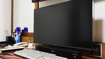A computer setup with a monitor, keyboard, and a soundbar.