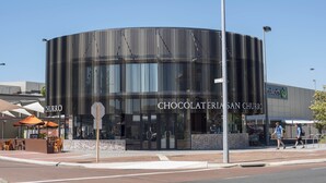 A modern building with a curved facade and the name "CHOCOLATERIA SAN CHURRO" displayed prominently. - Midland Haven - Midland WA (Midland)
