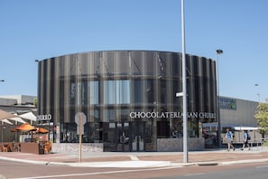 A modern building with a curved facade and the name "CHOCOLATERIA SAN CHURRO" displayed prominently. - Midland Haven - Midland WA (Midland)