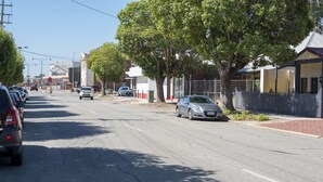 A street with parked cars, trees, and buildings. - Midland Haven - Midland WA (Midland)