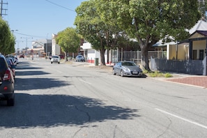 A street with parked cars, trees, and buildings. - Midland Haven - Midland WA (Midland)