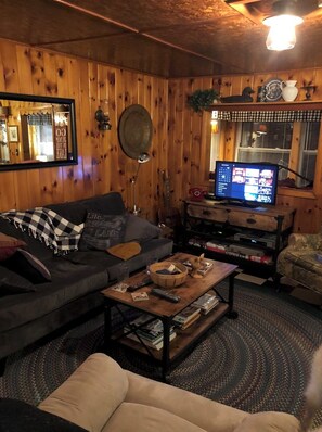 Relax in this inviting living room with a comfortable sofa, coffee table, and TV on a wooden stand.