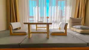 A modern room with a sofa, a small table, and a chair. - Dalian Bo Ke Business Apartment (Dalian)