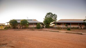 A two-story building with a sign reading "AMGREACH ADVENTURES." - Longreach Outback Adventures (Longreach)