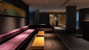 A modern interior with a seating area, a wooden table, and a decorative wall.