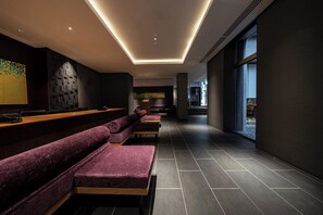 A modern hotel lobby with a long reception desk, purple seating, and a large window. - Hotel Vista Premio Kyoto Nagomitei (Kyoto)