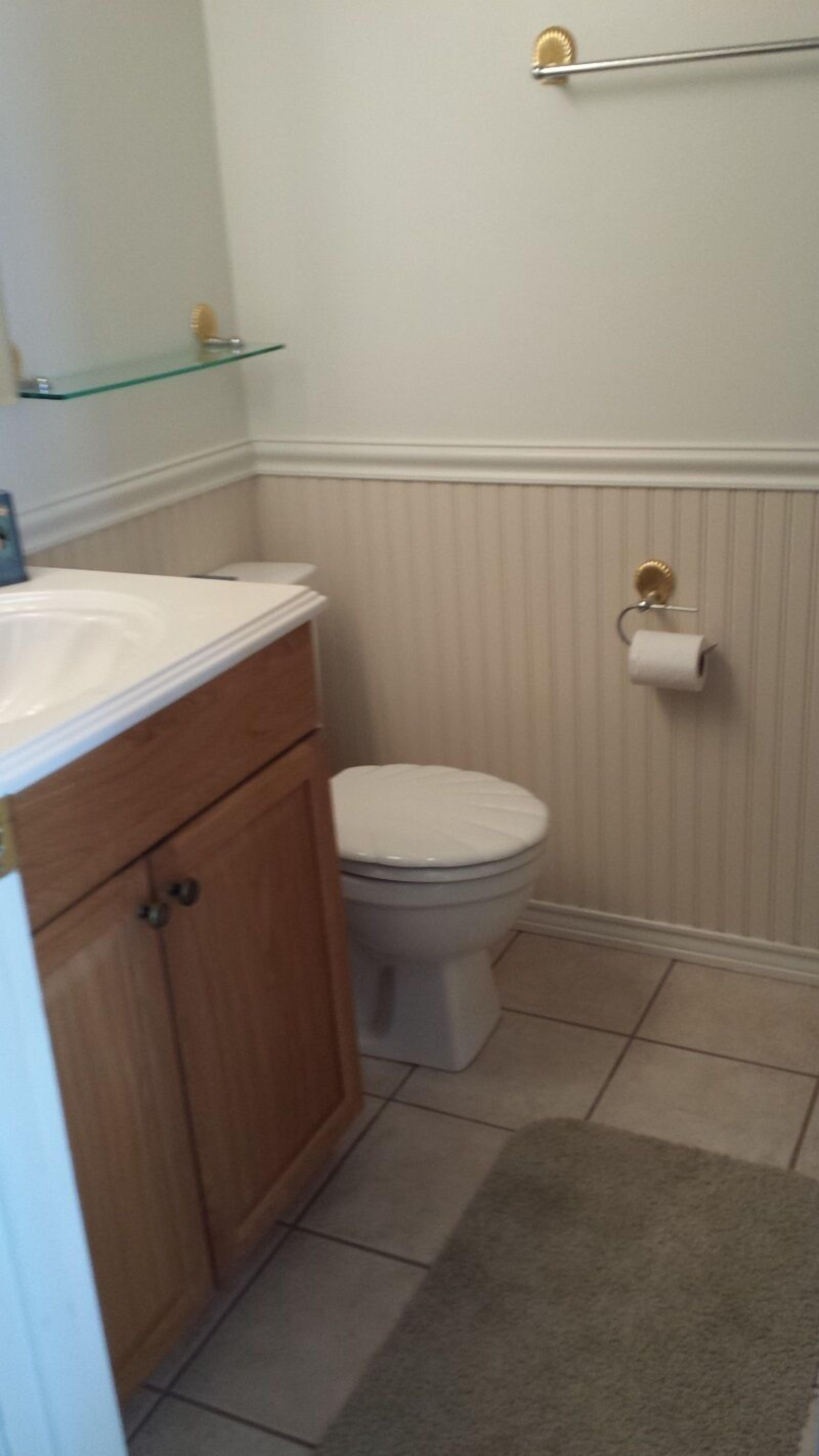 Un baño con inodoro, lavamanos y espejo.