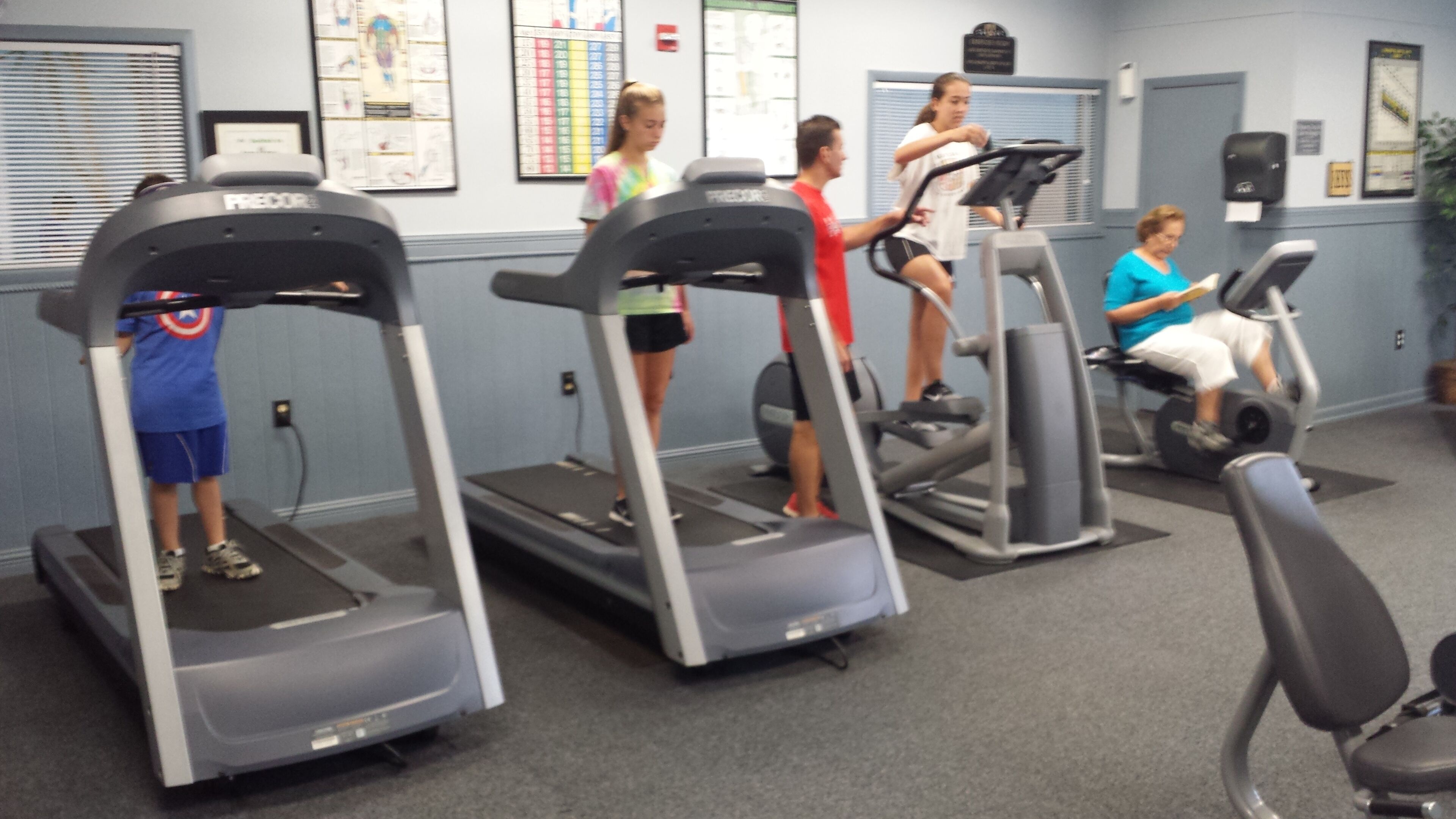 A gym with treadmills, stationary bikes, and exercise equipment.