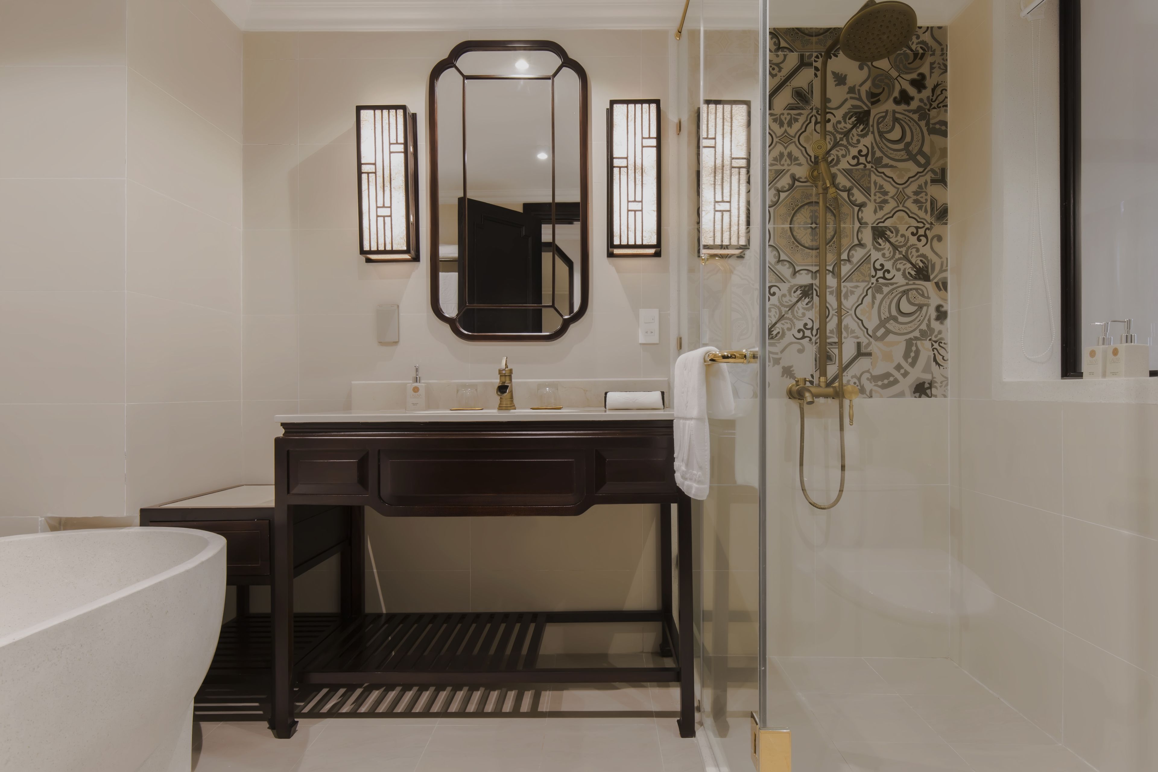 A modern bathroom with a freestanding bathtub, a vanity with a mirror, and a shower area.