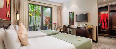 A hotel room with two beds, a desk with a chair, a TV, and a wardrobe.
