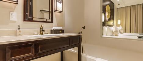A modern bathroom with a large mirror, a bathtub, and a vanity with a sink.