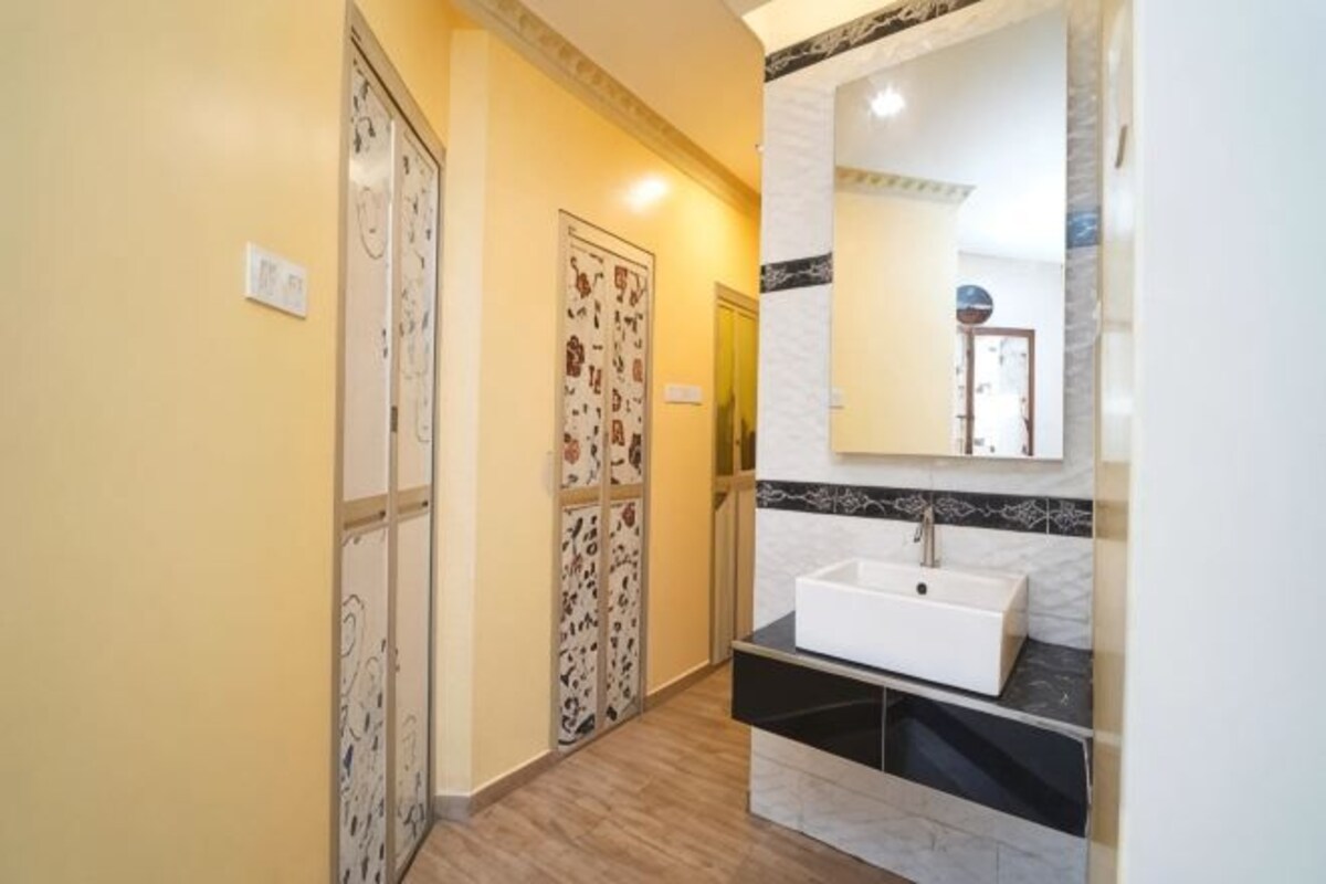 A hallway with patterned doors, a sink, and a mirror.