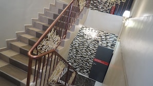 A staircase with wooden steps and a metal railing. - Ghazrin's Classic Hotel (Johor Bahru)