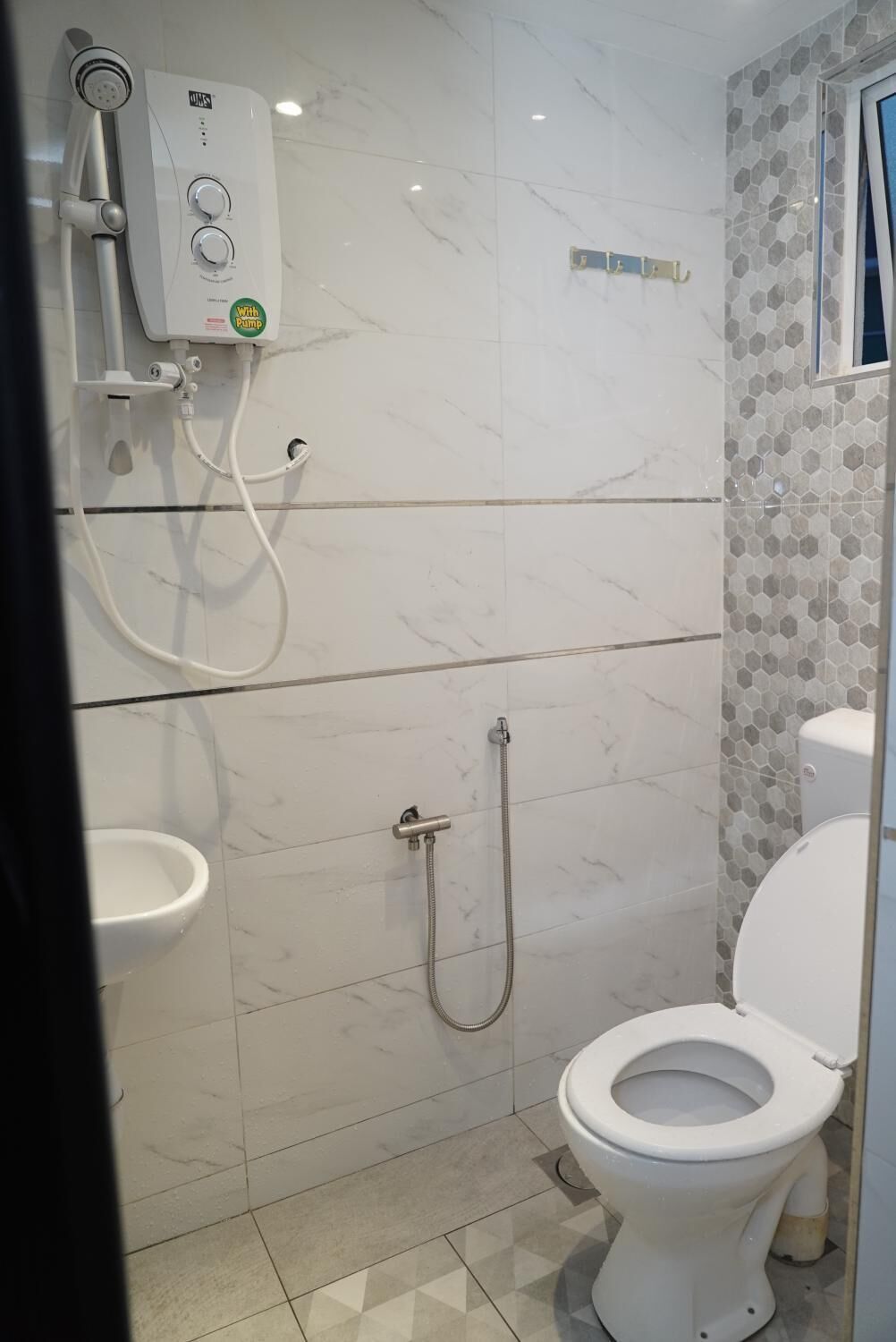 Une salle de bain équipée de toilettes, d’une douche et d’un bidet.