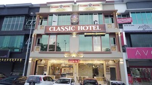 A Classic Hotel with a prominent sign, multiple floors, and a Butik & Cafe adjacent to it. - Ghazrin's Classic Hotel (Johor Bahru)