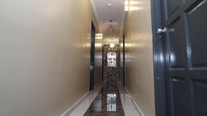 A hallway with a marble floor, a patterned wall, and a door on the right. - Ghazrin's Classic Hotel (Johor Bahru)
