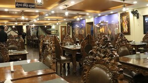 An ornate dining area with wooden furniture and chandeliers.