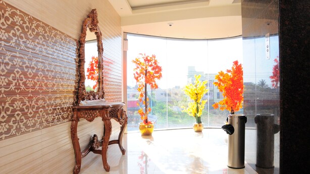 A modern interior with a large mirror, decorative wall, and potted plants near a window.