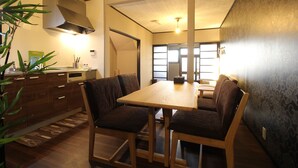 A modern kitchen with wooden cabinets, a built-in stove, and a large window. - Kyoto Kyo-Hiiragi (Kyoto)