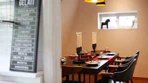 A dining area with a menu board, candles, and a window with a view of a chair outside. - Tribear House 1 (Seoul)