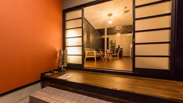 A traditional Japanese-style room with sliding doors, a wooden floor, and a small seating area with a table and chairs. - Kyoto Kyo-Tsubaki (Kyoto)