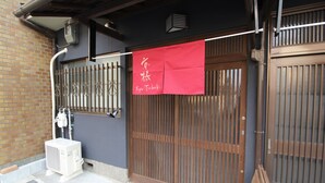 A traditional Japanese entrance with a sliding door and a red banner. - Kyoto Kyo-Tsubaki (Kyoto)