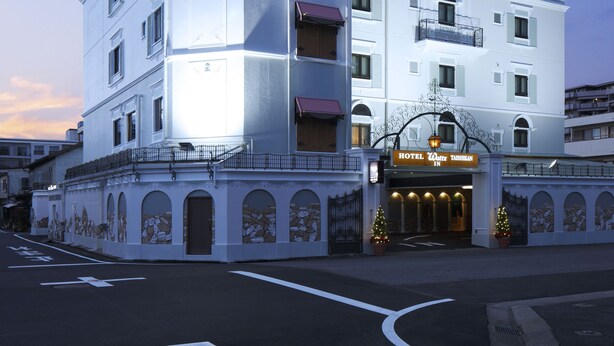 Un hotel de varios pisos con un cartel llamativo que dice "HOTEL Waltz".