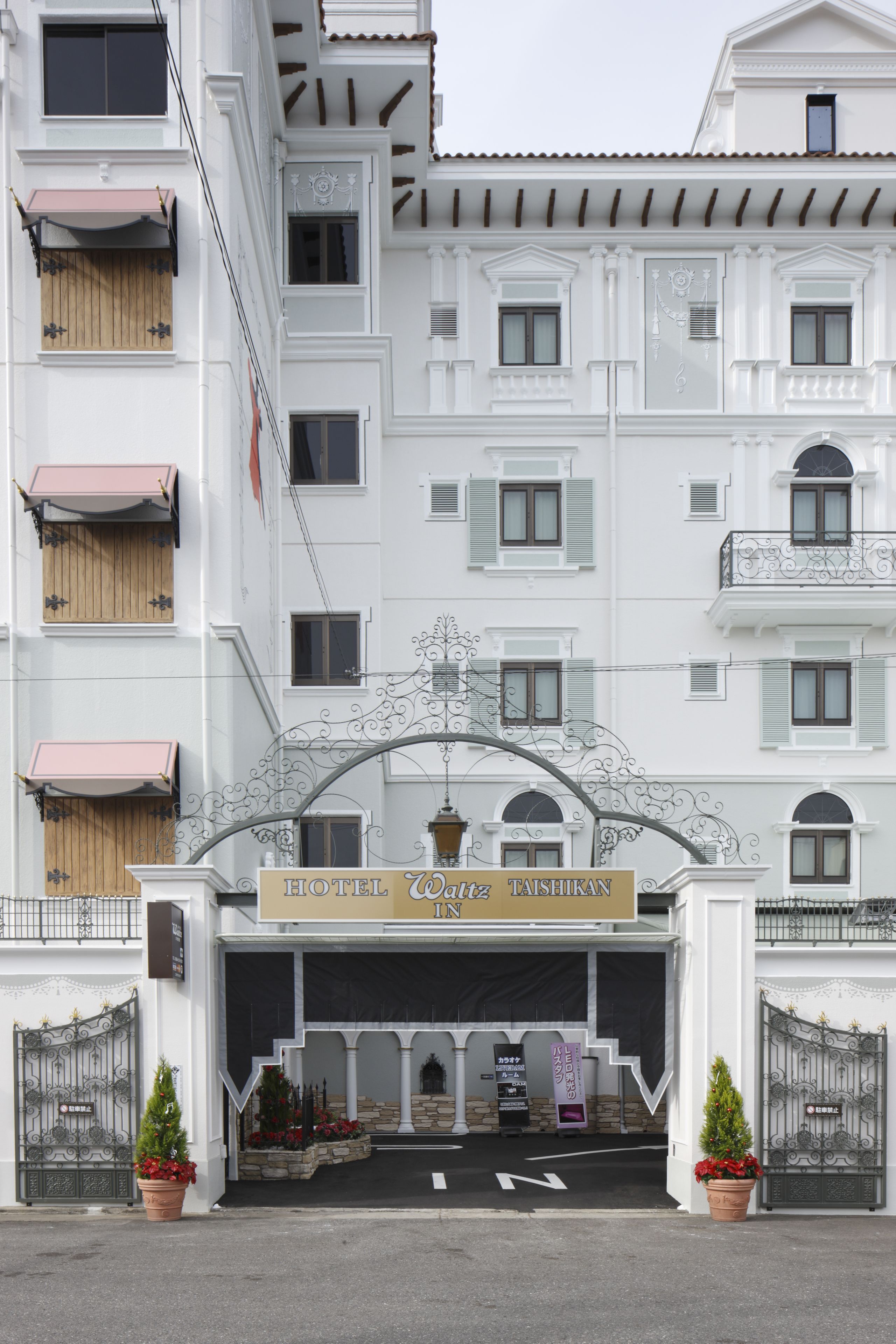 A white building with a sign reading "HOTEL Taishukan".