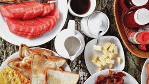 Uma mesa de café da manhã com diversos alimentos e bebidas.